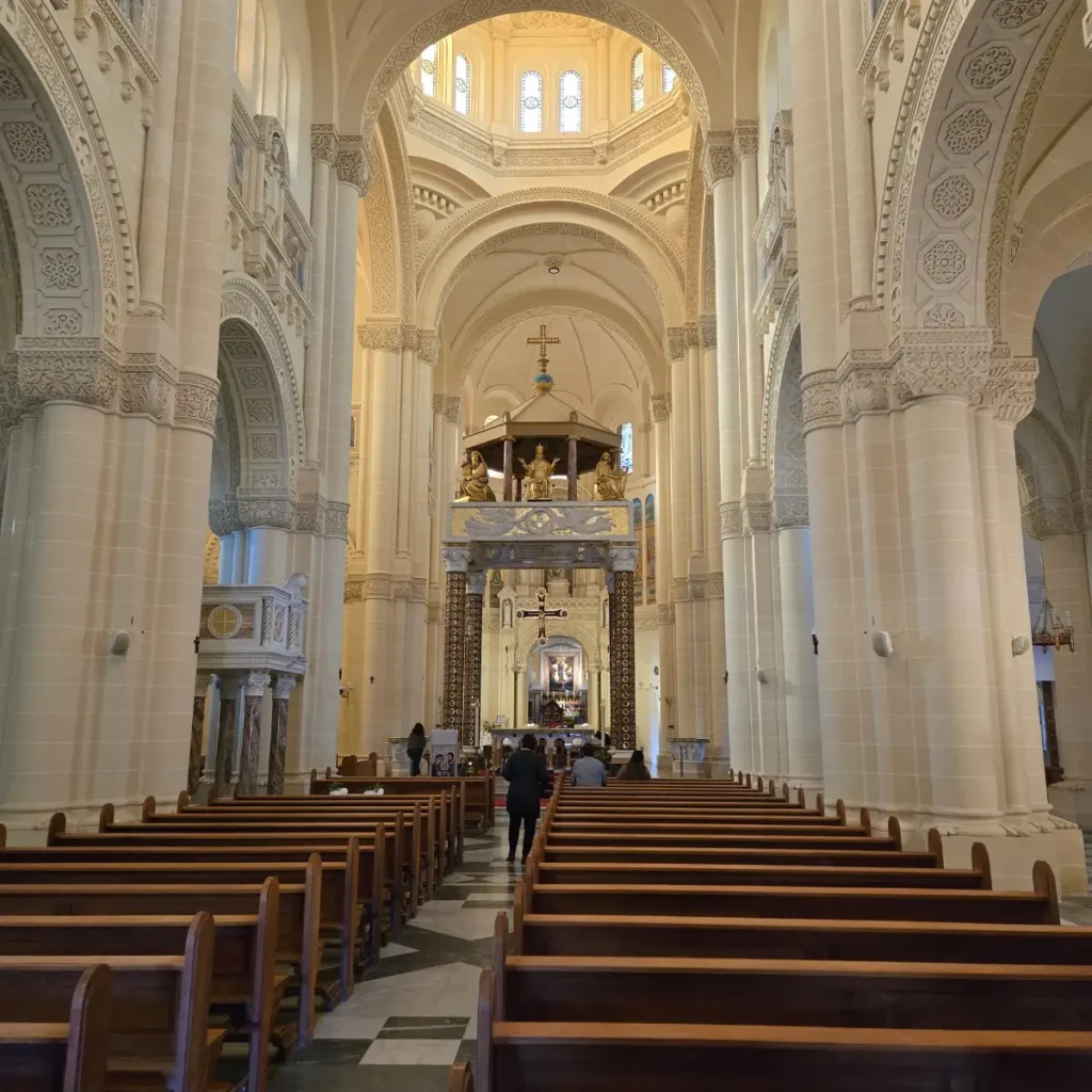 Interiorul Bazilicii Naționale a Sanctuarului Fecioarei Maria de Ta' Pinu, Għarb, insula Gozo, Malta, prezentând altarul și nava centrală cu arhitectură neo-romantică.