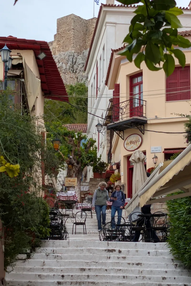 Stradă îngustă plină de cafenele în cartierul Plaka din Atena