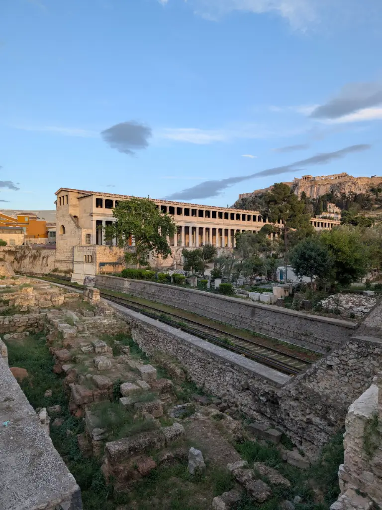 Atena la apus: Acropole și Agora, o cină cu istoria la picioare Priveliște panoramică de la terasa unde am luat cina în Atena, cuprinzând Agora Antică luminată și măreția Acropolei, simbol al istoriei grecești.