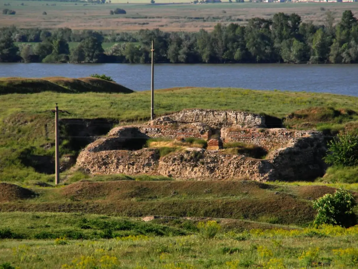 Ruinele Cetății Noviodunum, fostă fortificație romană lângă Dunăre, cu ziduri vechi de piatră și o panoramă cu apă și vegetație