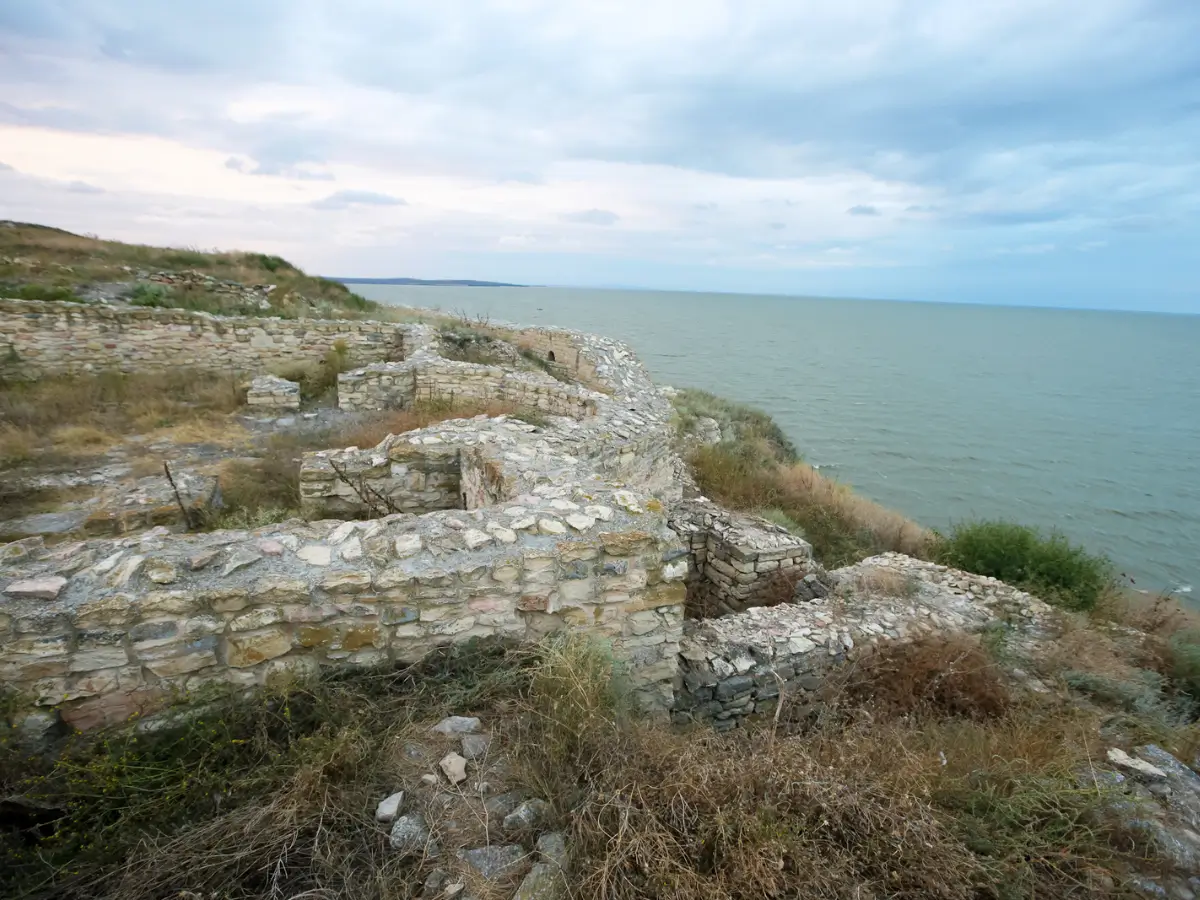 Ruinele Cetății Argamum, veche așezare greco-română pe malul Mării Negre, cu ziduri de piatră și vegetație înconjurătoare