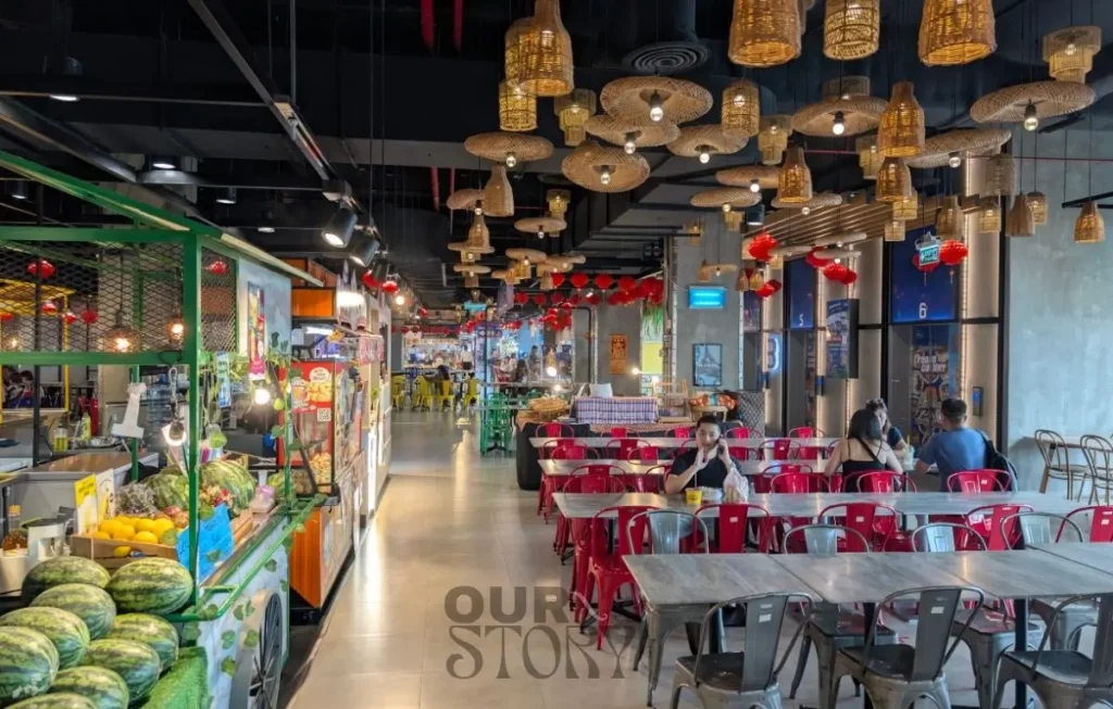 Food court modern din Chatuchak Weekend Market cu fructe proaspete și mese roșii, opțiune de prânz low budget în city break