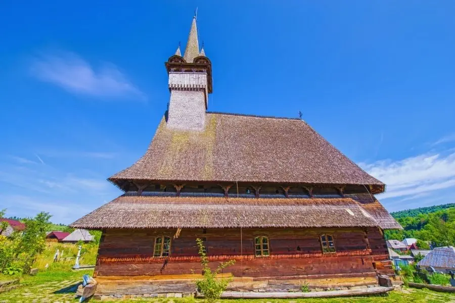 Biserică de lemn UNESCO din Maramureș — turlă înaltă și zveltă specifică arhitecturii maramureșene