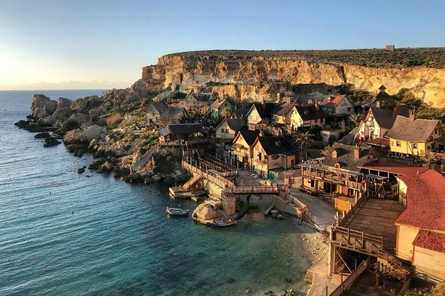Panoramă peste Popeye Village din golful Anchor Bay, Malta