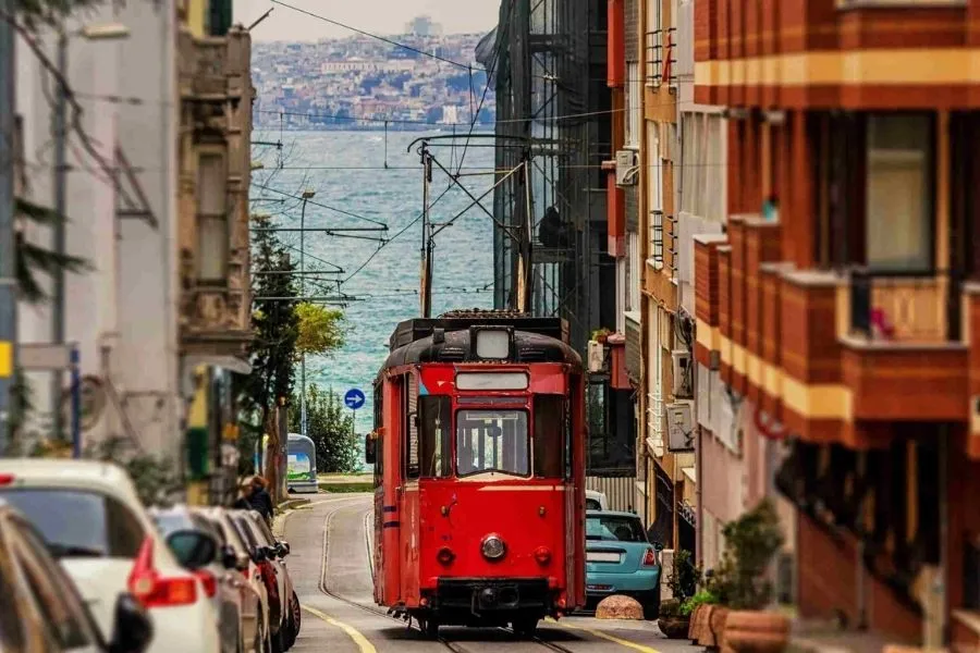 Scenă vibrantă de pe Strada Istiklal din Istanbul cu tramvaiul roșu nostalgic în prim-plan — simbol al Istanbulului modern