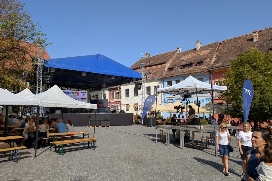 Piața Cetății din Sighișoara cu case medievale pastelate, terase și Turnul cu Ceas în fundal — centrul vieții sociale al cetății medievale UNESCO